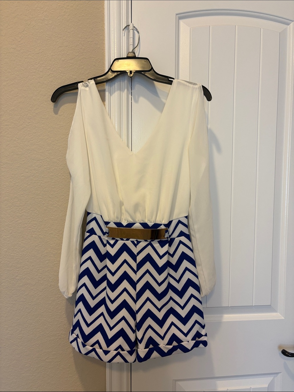Ivory and Royal Blue Chevron Long-Sleeve Romper with chrome waist accent.